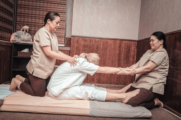 Professional skilled Asian masseuses working in pair — Stock Photo, Image