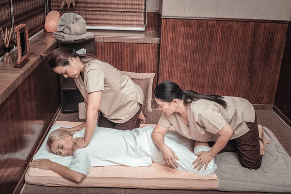Dwie profesjonalne masażystki kobiece masowania ciała klientów — Zdjęcie stockowe