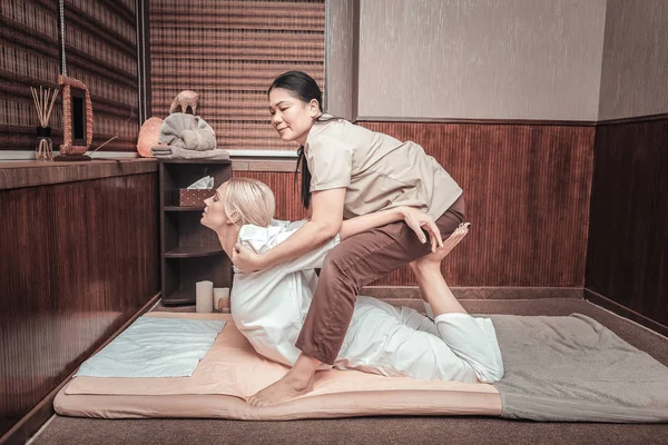 Skilled mulher asiática fazendo massagem para seu cliente — Fotografia de Stock