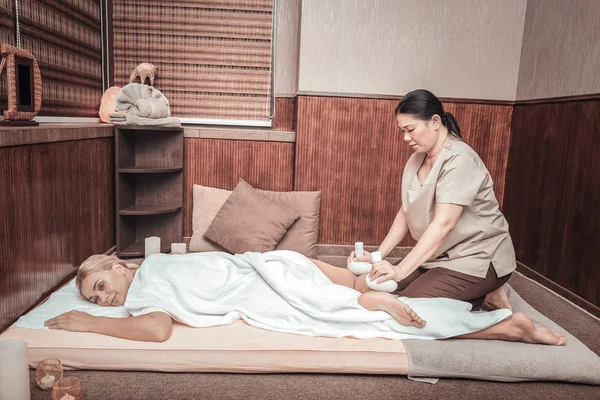 Leuke ontspannen vrouw genieten van de massage met zakken — Stockfoto