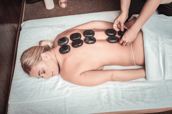 Bovenaanzicht van mooie jonge vrouw met steen massage — Stockfoto