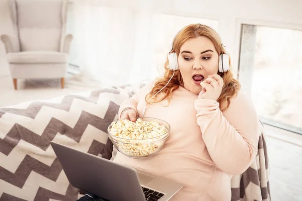 Unangenehme Plus-Size-Frau schaut Film auf ihrem Laptop — Stockfoto