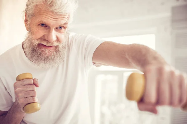 Joyful gray-haired man preparing for yearly competition