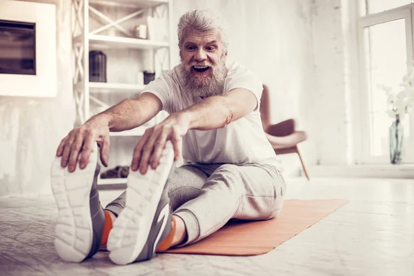 Allegro uomo dai capelli grigi che guarda i suoi piedi — Foto Stock