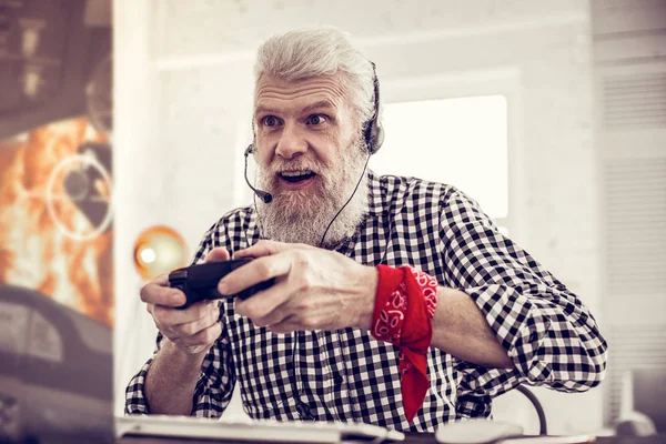Радостный зрелый мужчина с удовольствием играет в компьютерные игры — стоковое фото