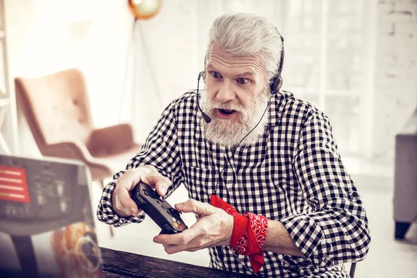 Grave uomo dai capelli grigi che gioca ai videogiochi — Foto Stock