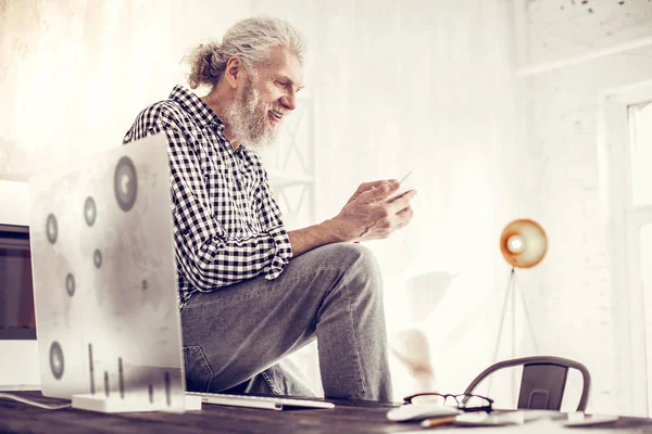 Kind bearded man looking at screen of his gadget — Stock Photo, Image