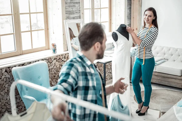 Модный дизайнер в полосатой рубашке, стоящий возле формы платья — стоковое фото