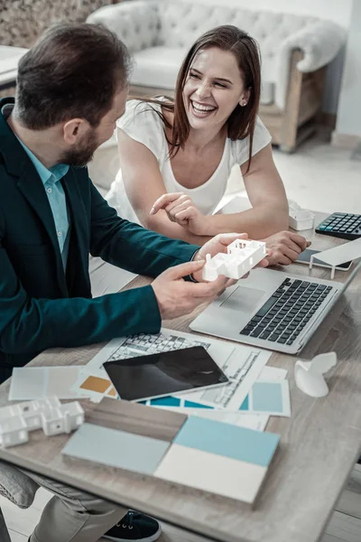 Dunkelhaarige Frau lacht, während sie mit ihrem Mann arbeitet — Stockfoto