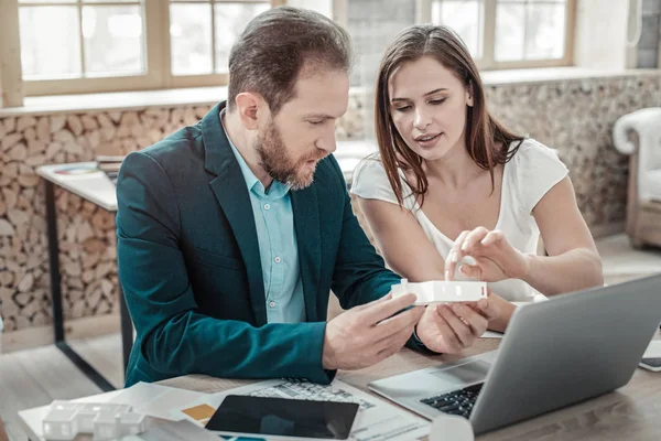 Hilfreiche Ehefrau unterstützt ihren Mann bei der Arbeit an einem neuen Projekt — Stockfoto