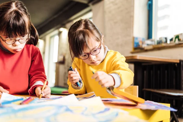 Sisters having Down syndrome coloring pictures in rehabilitation center — Stock Photo, Image