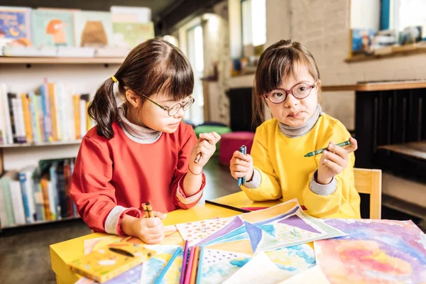 Two preschool girls playing and coloring pictures in rehabilitation center — Stock Photo, Image