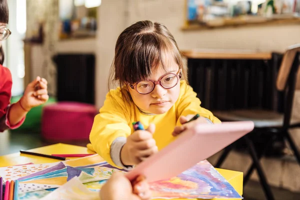 Cute dark-haired girl with Down syndrome wearing glasses — Stock Photo, Image