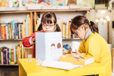 İlginç kitaba bakmalısın kırmızı kazak giyen kara gözlü güneşli çocuk