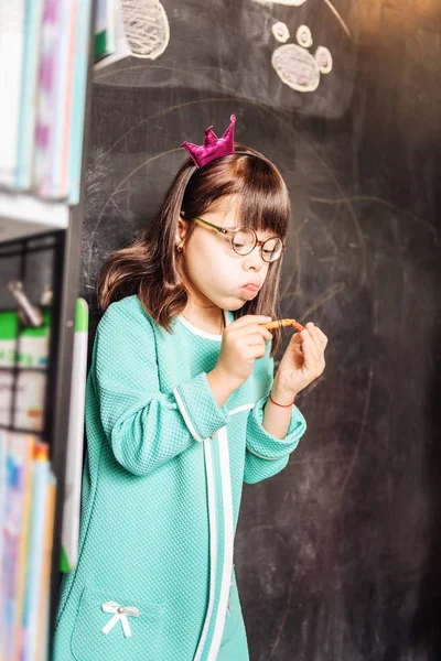 Funny dark-eyed sunny child wearing glasses and little crown — Stock Photo, Image