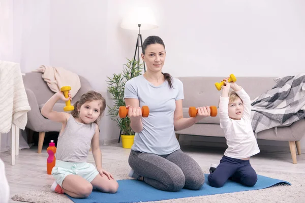 Entzückte nette Familie beim gemeinsamen Hantelheben — Stockfoto