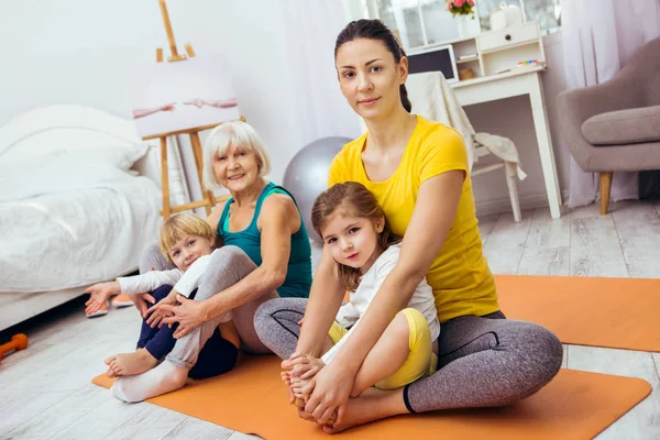 Trevlig trevlig kvinna som sitter på yogamattan — Stockfoto