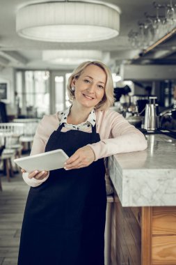 Olgun güzel sarışın kadın kendi restoranda ayakta