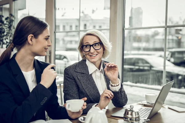 Стильная элегантная деловая женщина разговаривает со своей молодой секретаршей — стоковое фото