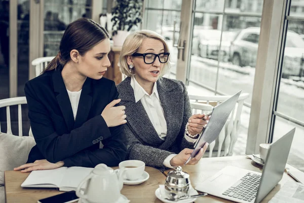 Femeie de afaceri purtând ochelari vorbind cu tânărul ei angajat — Fotografie, imagine de stoc
