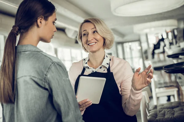 Smiling pleasant employer speaking with her young employee — Φωτογραφία Αρχείου