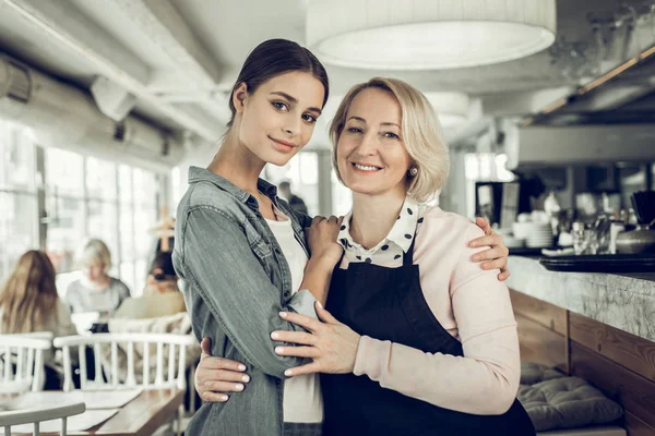Moeder en dochter knuffelen terwijl je in familierestaurant — Stockfoto