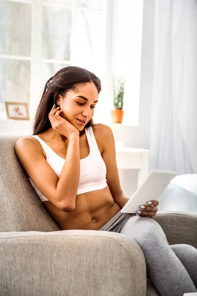 Mujer morena soñadora mirando la pantalla de su tableta —  Fotos de Stock