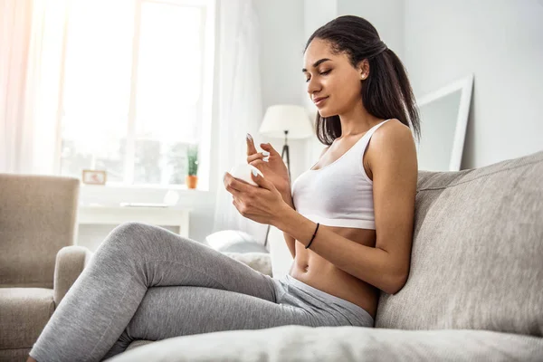 Agradable morena mujer tratando de cosméticos para el cuerpo —  Fotos de Stock