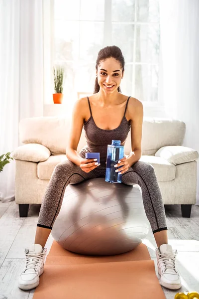 Güzel esmer kadın fitness topu üzerinde oturan