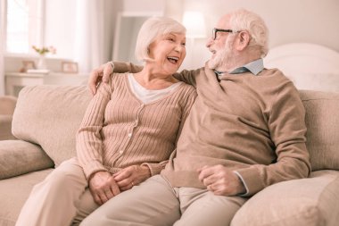 Neşeli gri saçlı erkek kişi eşi kucaklayan