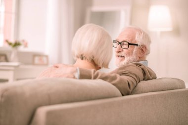 Karısı yakın oturan memnun gri saçlı adam