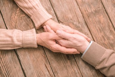 Üstten görünüm fotoğrafı, masanın üzerine eğilerek eller