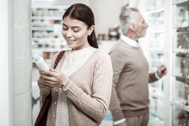 Eczane deposuna sevgi dolu babası duran gülen genç kadın
