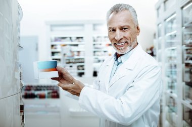 Doğruca kameraya bakarak neşeli üst düzey eczacı