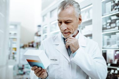 Tabletleri kutusu bakan özenli olgun adam