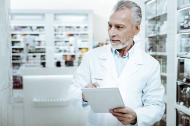 Handsome medical worker using his modern tablet