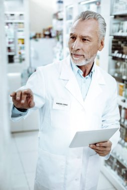 Attentive male person checking the amount of medicine