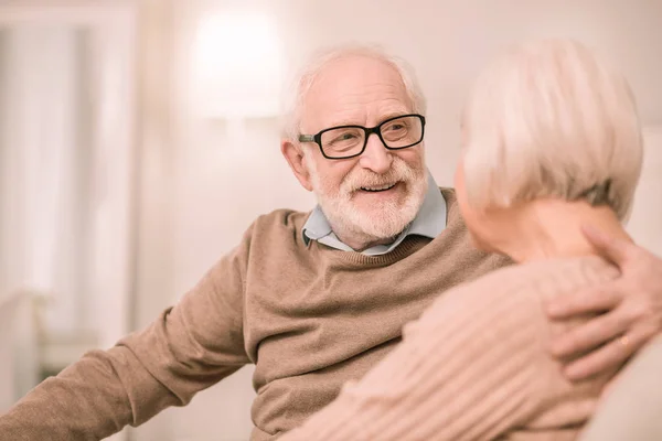 Веселый пенсионер смотрит в глаза своей жене — стоковое фото