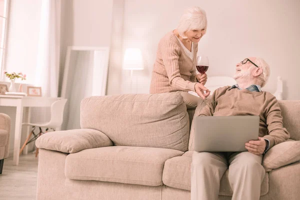 Mulher aposentada agradável apontando para a tela do laptop — Fotografia de Stock