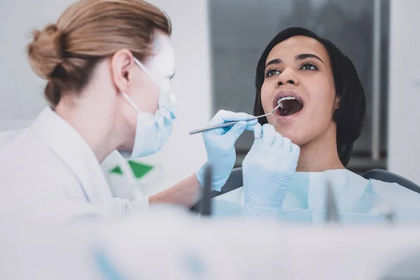 Estomatólogo profesional joven atento haciendo chequeo dental — Foto de Stock