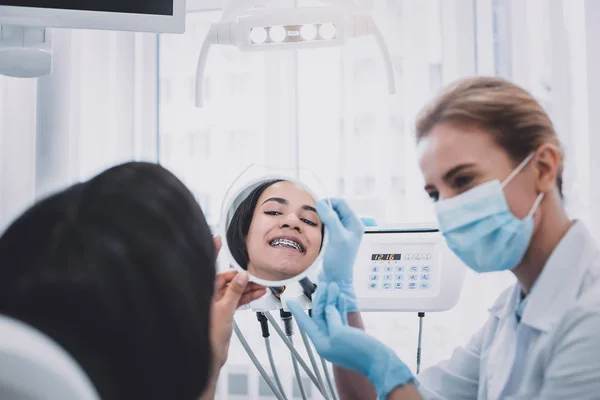 Positive delighted patient looking at her smile — Stock Photo, Image