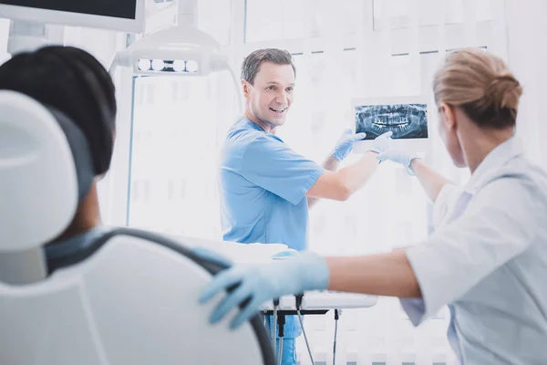 Homme joyeux démontrant une image radiographique à un collègue — Photo