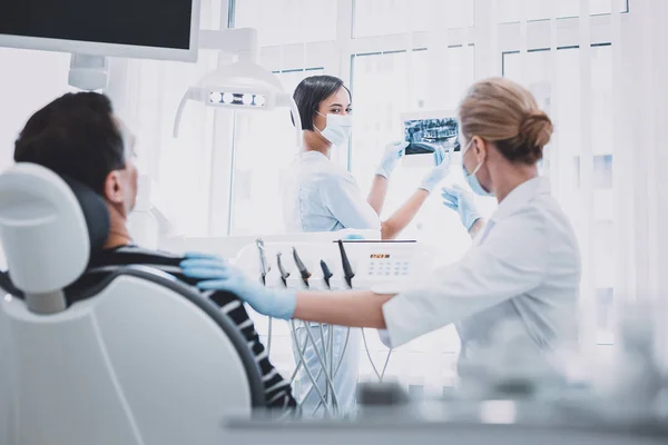 Professionelle Stomatologin erklärt ihrem Assistenten — Stockfoto