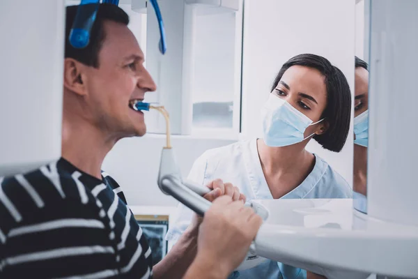 Dentista internacional grave que controla a produção de imagens de roentgen — Fotografia de Stock