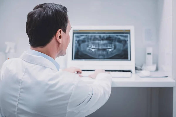 Blij jonge stomatologist tanden van zijn patiënt controleren — Stockfoto