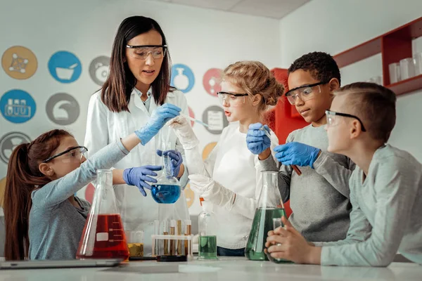 Profesora atenta mostrando experimento químico a su alumno — Foto de Stock