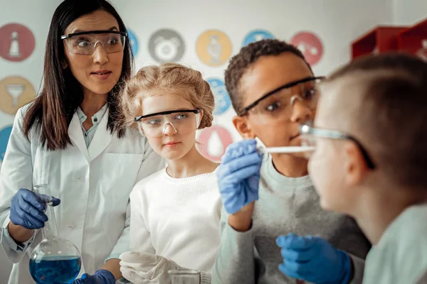 Niños internacionales jugando juntos con reactivo químico — Foto de Stock