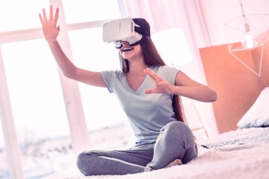 Young girl wearing modern virtual reality glasses