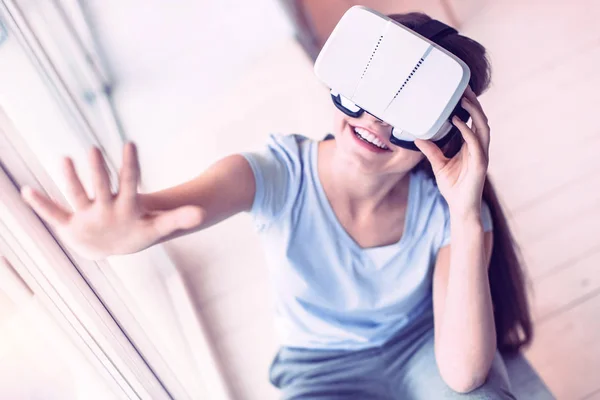 Chica bonita tratando de dispositivo de realidad virtual en casa —  Fotos de Stock