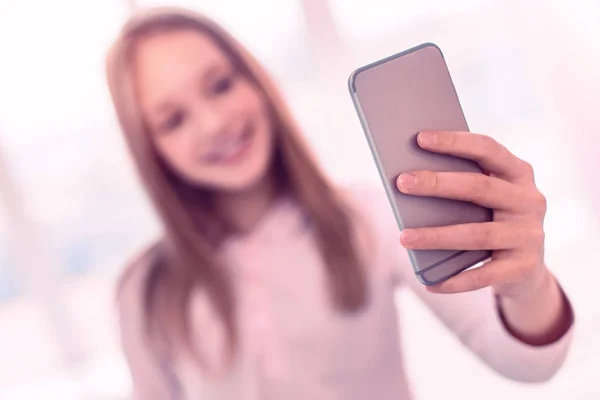 Selektiver Blick auf Smartphone mit Mädchen beim Selfie im Hintergrund — Stockfoto
